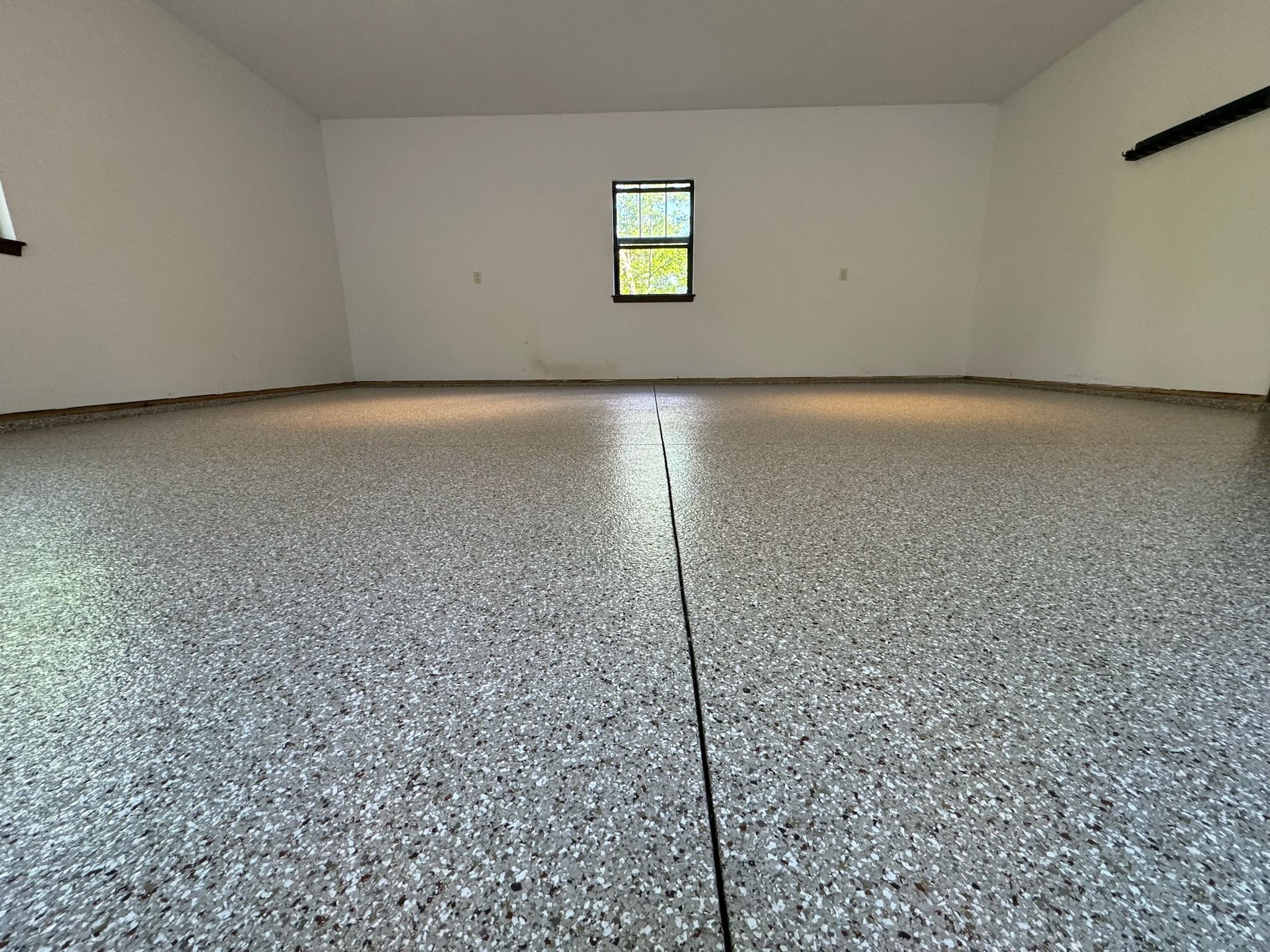 Detailed image of dark blue flake epoxy garage flooring, showcasing the intricate flake distribution and reflective surface