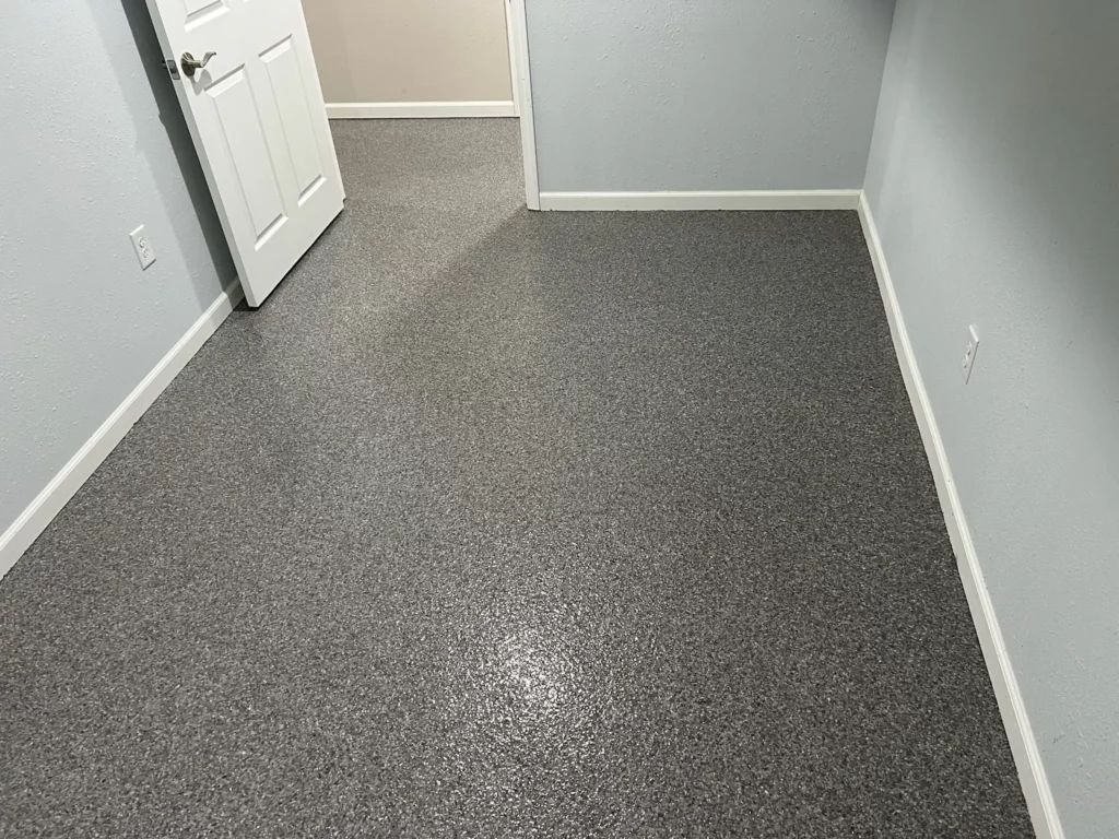 A newly refinished basement floor in O’Fallon, Missouri, with a durable polyurea coating for long-term protection.