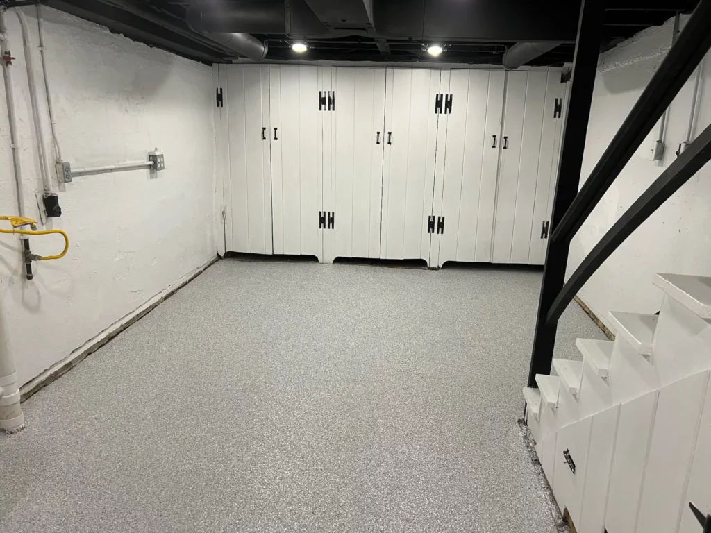 A Lake St. Louis basement with an epoxy floor and white cabinets.