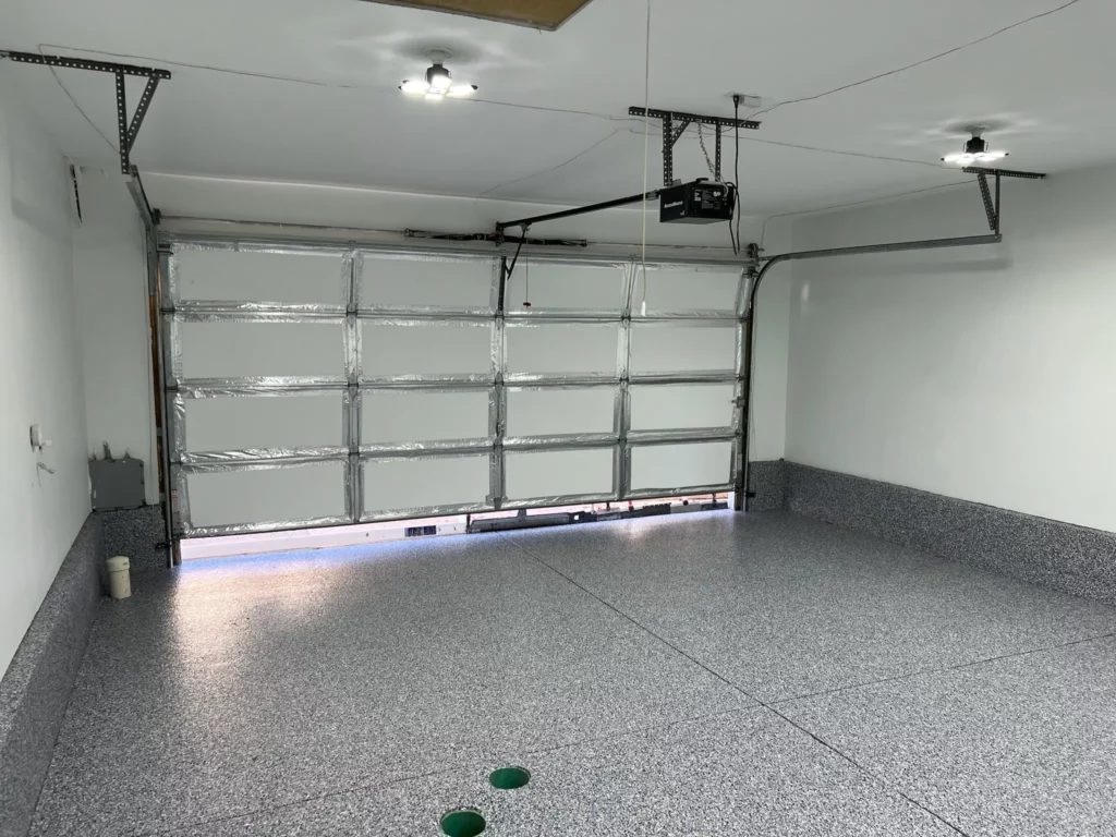 A garage in Lake St. Louis with an epoxy-coated floor and open door.