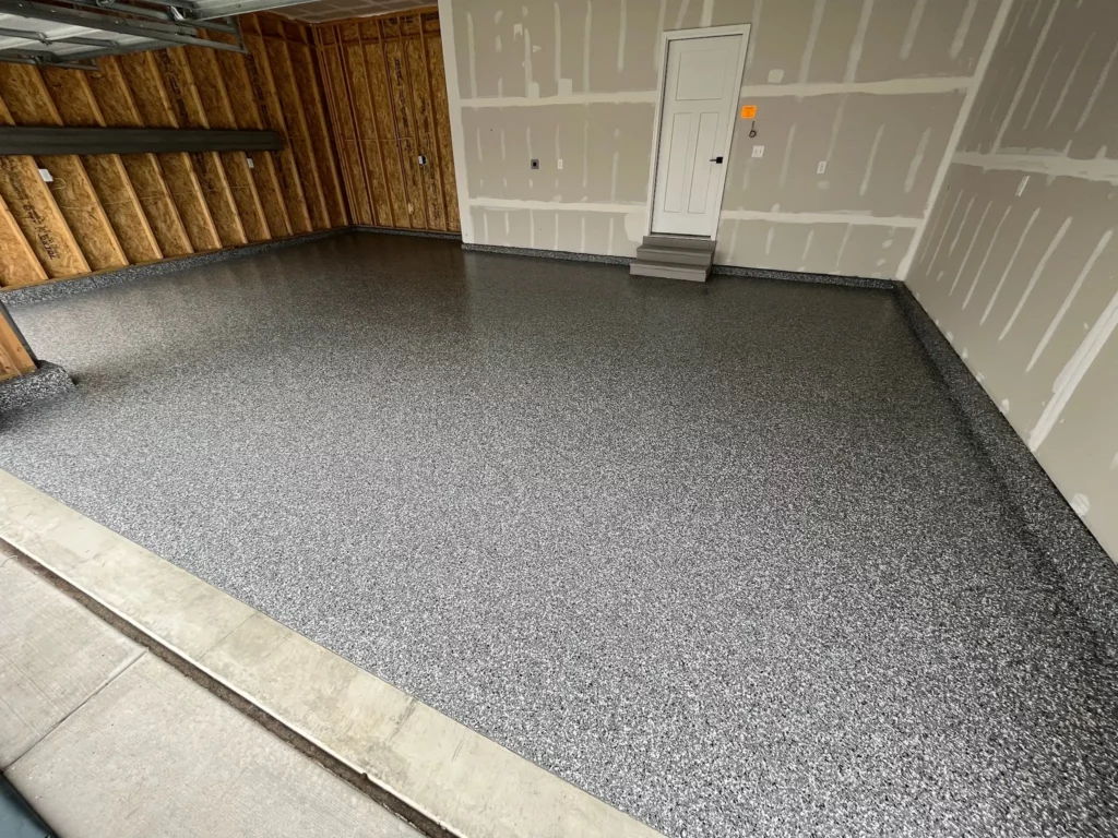 A Lake St. Louis garage with a newly installed epoxy floor, providing a polished and easy-to-clean surface.